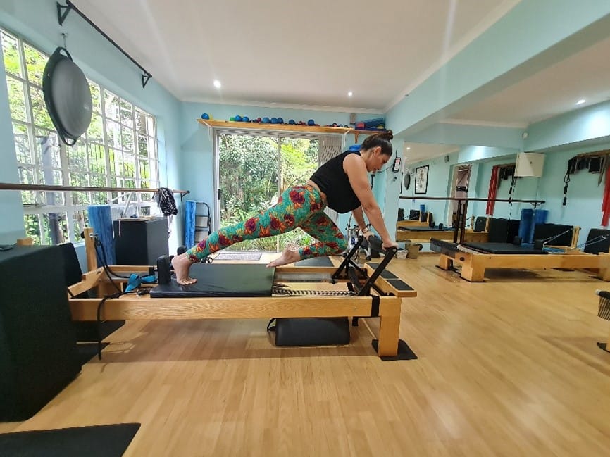 Pilates teacher demonstrating a Reformer exercise variation