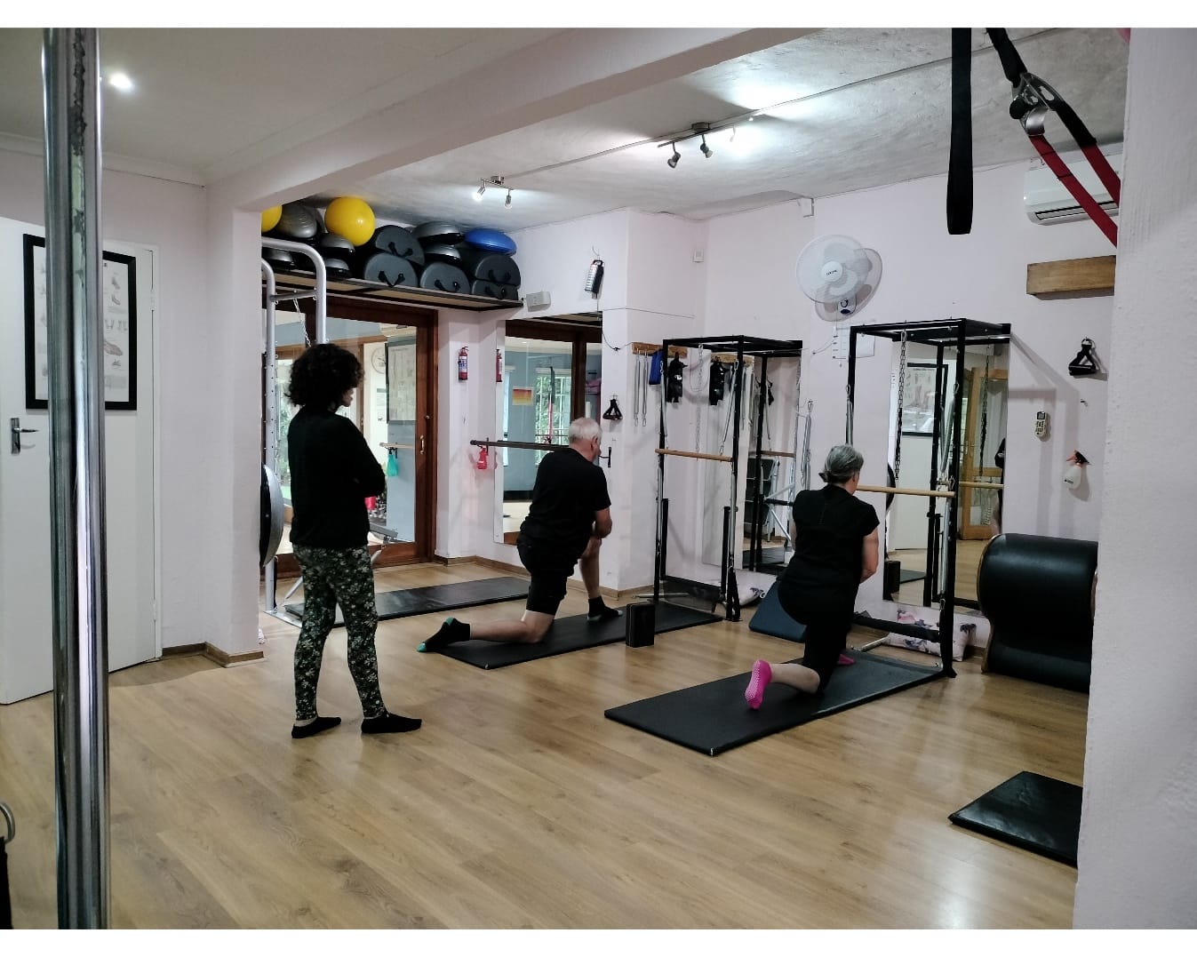 Instructor adjusting a client's alignment during Pilates