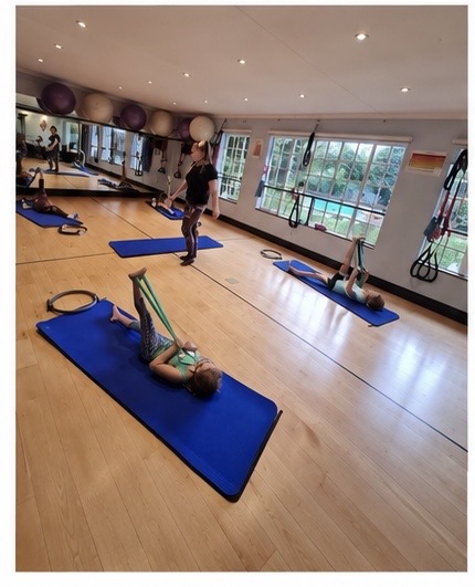 Instructor guiding children through a Pilates exercise