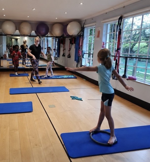 Kids Pilates class at Pilates Dynamics in Randburg, a girl balancing on a Pilates ring